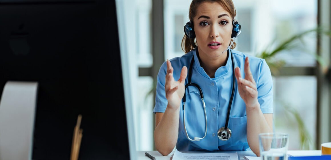 Young nurse with headset providing support while working at medi Healthcare Virtual Assistants vs In-House Staff: Which Is Better?