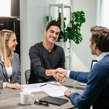 Happy couple shaking hands with their real estate agent at home. How Businesses Can Gain Greater Financial Control Through Captive Insurance